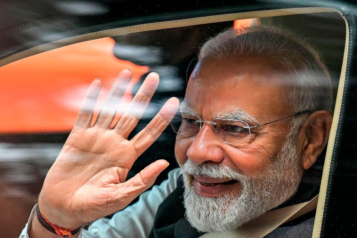 India’s Prime Minister Narendra Modi waves upon his arrival to inaugurate the new Vande Bharat passenger train and Yellow Line of the Namma Metro in Bengaluru on August 10, 2025. - AFP