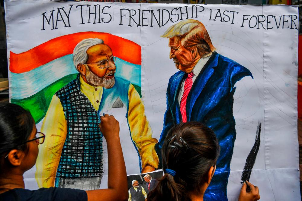 Students paint on canvas faces of US President Donald Trump (R) and India's Prime Minister Narendra Modi, in the street in Mumbai on Feb 21, 2020, ahead of the visit of US President in India. — AFP