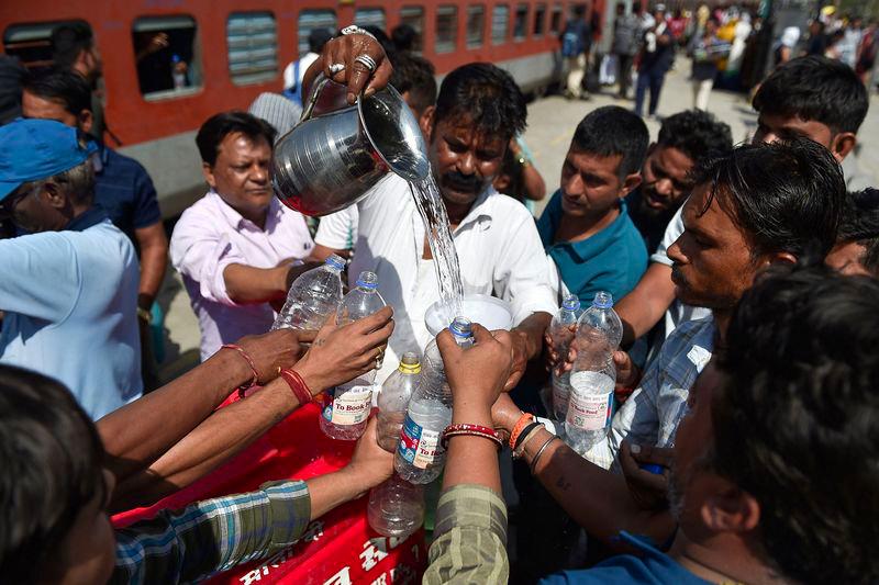 A volunteer distributes drinking water to train passengers on a hot summer day at the Jalandhar Cantonment railway station in Jalandhar on May 28, 2024. - AFPPIX