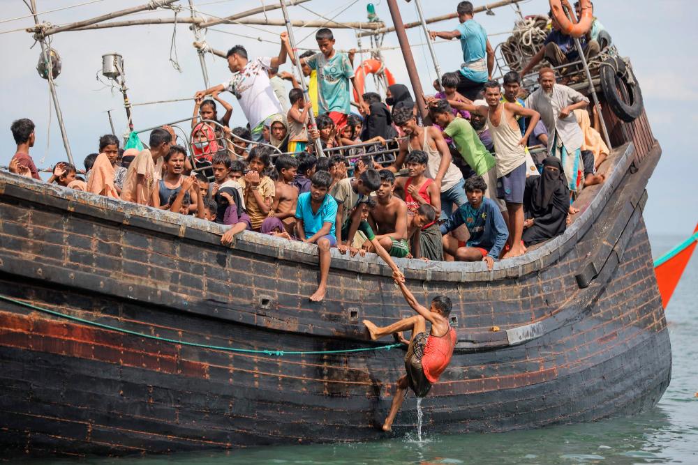 TOPSHOT - Newly arrived Rohingya refugees are stranded on a boat as the nearby community decided not to allow them to land after providing water and food in Pineung, Aceh province on November 16, 2023. - AFPPIX