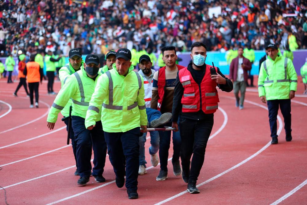 Iraqi stadium security team members carry an injured football fan into an emergency area at the Basra International Stadium following a stampede ahead of this evening’s final match of the Arabian Gulf Cup between Iraq and Oman, on January 19, 2023 in Basra. AFPPIX