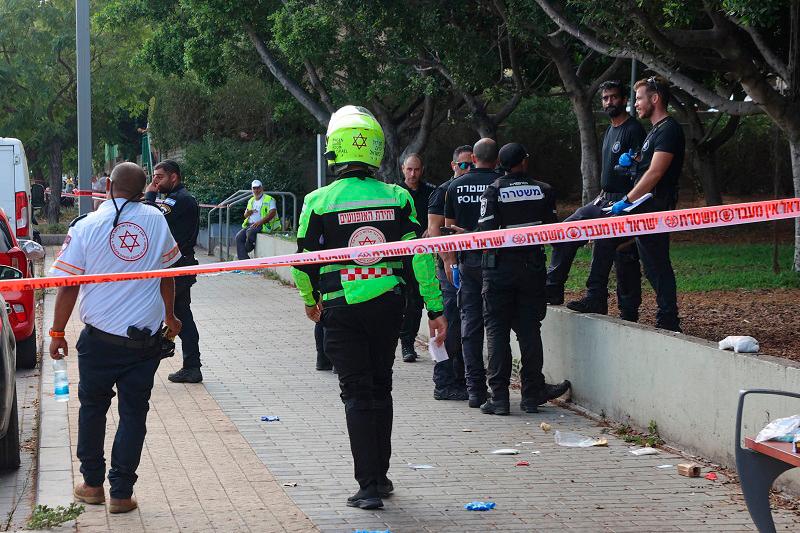 Israeli police and first responders gather at the scene of a reported stabbing attack in Holon in the southern suburb of Tel Aviv on August 4, 2024. One woman was killed and three other people wounded in the attack, Israel’s emergency medical service said, with police reporting a Palestinian suspect was “neutralised”. (Photo by GIL COHEN-MAGEN / AFP)