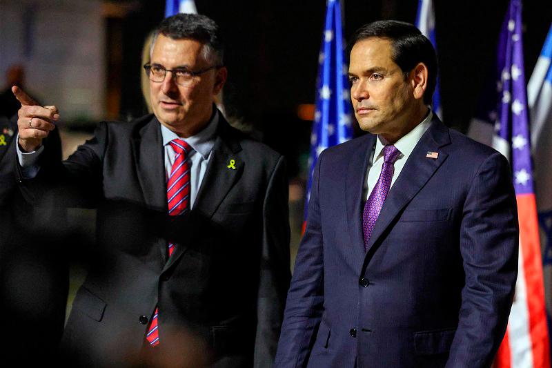 Israel's Foreign Minister Gideon Saar (L) welcomes US Secretary of State Marco Rubio upon arrival at Israel's Ben Guiron Airport in Lod on February 15, 2025 on the first leg of his Middle East trip. - Evelyn Hockstein / POOL / AFP