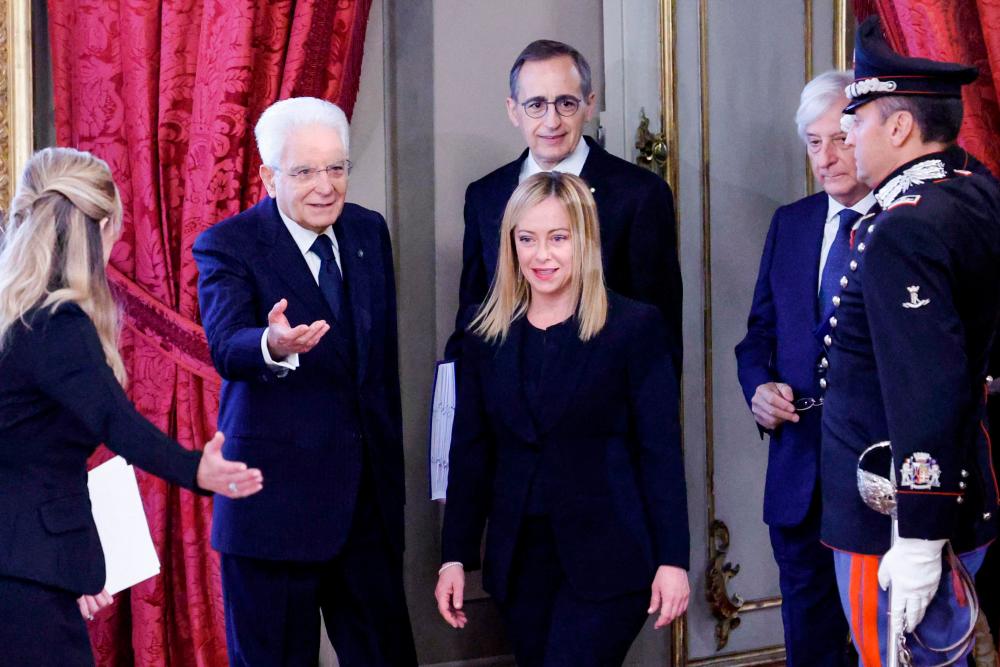 Italian President Sergio Mattarella (2nd L) welcomes new Prime Minister Giorgia Meloni (C) as she arrives for the swearing-in ceremony of the new Italian Government at the Quirinal Palace in Rome on October 22, 2022. AFPPIX