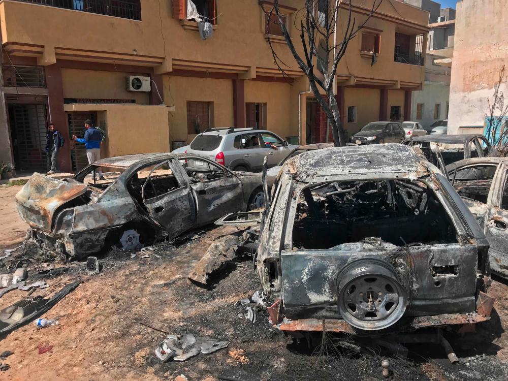Two men stand at the scene of an overnight rocket attack, which no group claimed responsibility for so far, in the Libyan capital Tripoli on April 17, 2019. A number of rockets struck parts of Tripoli late yesterday after strongman Khalifa Haftar launched an offensive earlier this month to take the Libyan capital, witnesses and AFP journalists said. — AFP