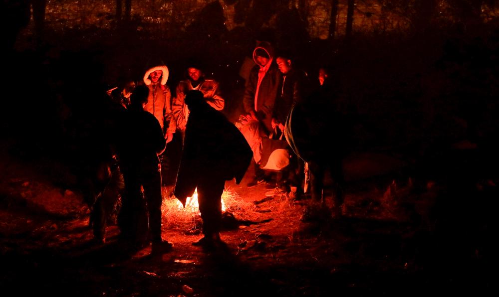 Migrants warm themselves next to a bonfire in Ciudad Juarez, Chihuahua State, Mexico, on December 28, 2023/AFPPix