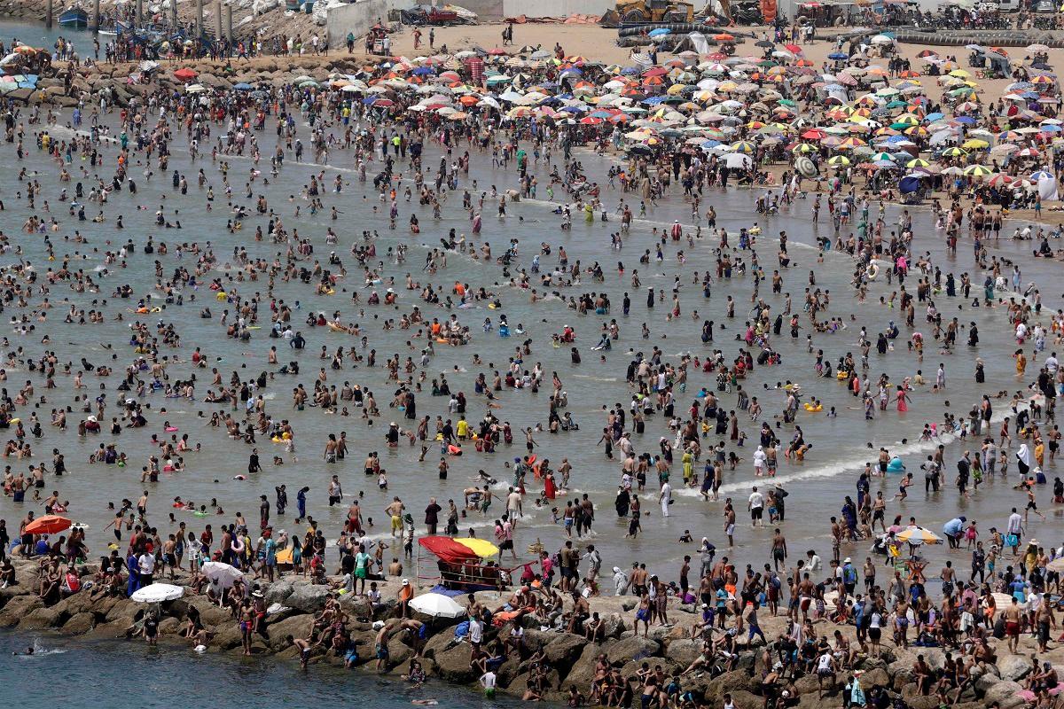 People cool off at a beach during a heatwave in Rabat on June 29, 2025. Monthly temperature records have been broken across Morocco, sometimes topping seasonal norms by as much as 20 degrees Celsius. - Abdel Majid BZIOUAT / AFP