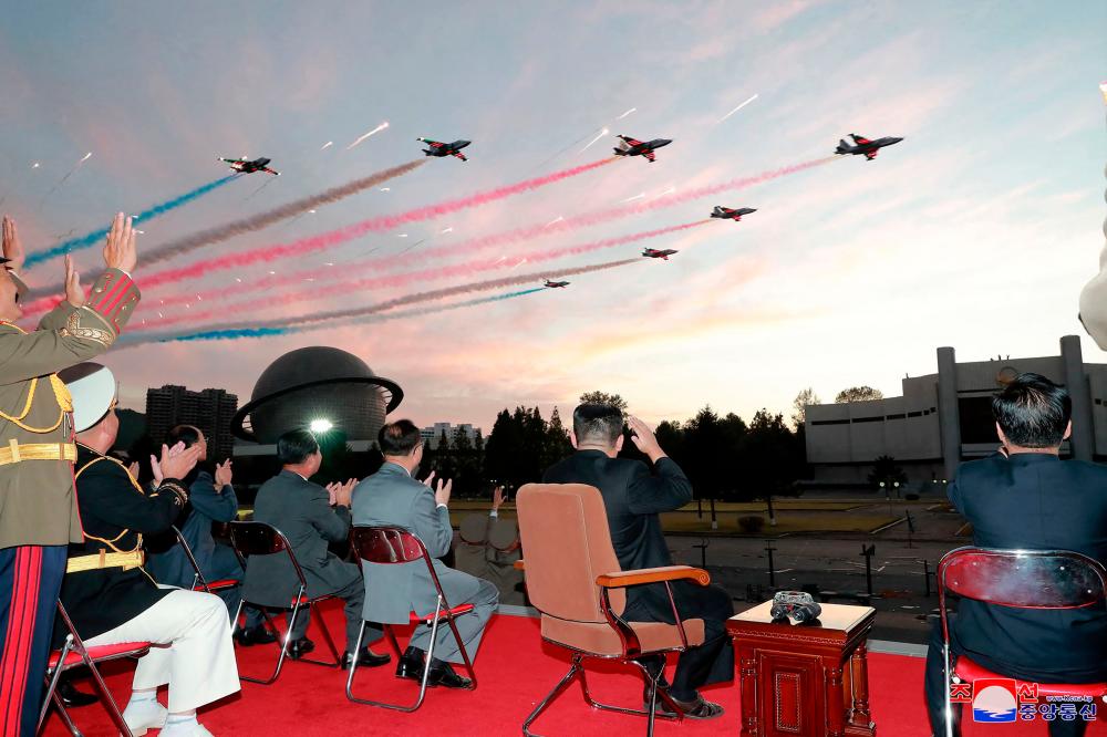 This picture taken on October 11, 2021 and released from North Korea’s official Korean Central News Agency (KCNA) on October 12 shows North Korean leader Kim Jong Un (2nd-R) watching a demonstration flight during the opening ceremony of the defence development exhibition “Self-Defence-2021” in Pyongyang. AFPpix