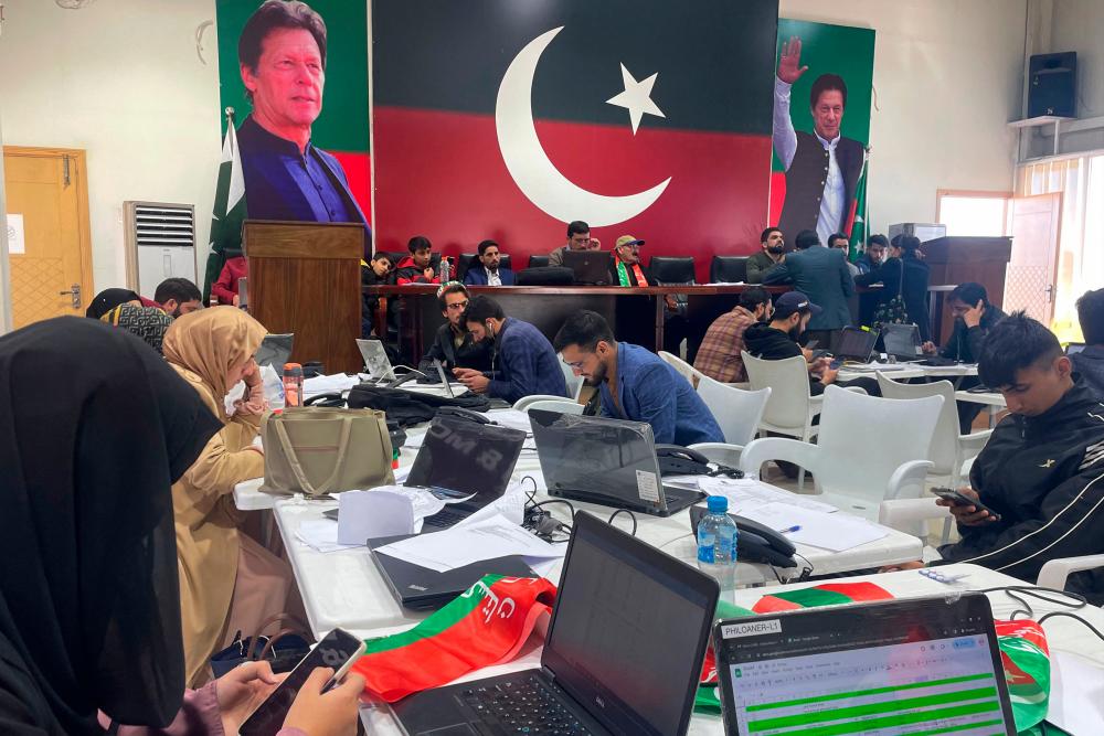 Workers are pictured at the central election monitoring cell of Pakistan Tehreek-e-Insaf (PTI) at the party office in Islamabad on February 8, 2024. Millions of Pakistanis began voting February 8 in an election marred by allegations of poll rigging, with the country’s most popular politician in jail and a military-favoured candidate tipped to win/AFPPix