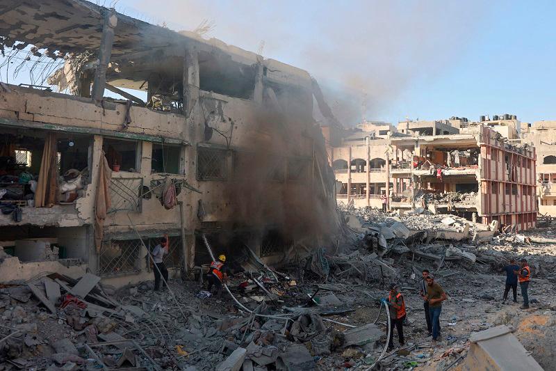 Palestinian rescuers extinguish a fire in a destroyed building following Israeli bombardment which hit a school complex, including the Hamama and al-Huda schools, in the Sheikh Radwan neighbourhood in the north of Gaza City on August 3, 2024, amid the ongoing conflict between Israel and the militant Hamas group. - (Photo by Omar AL-QATTAA / AFP)