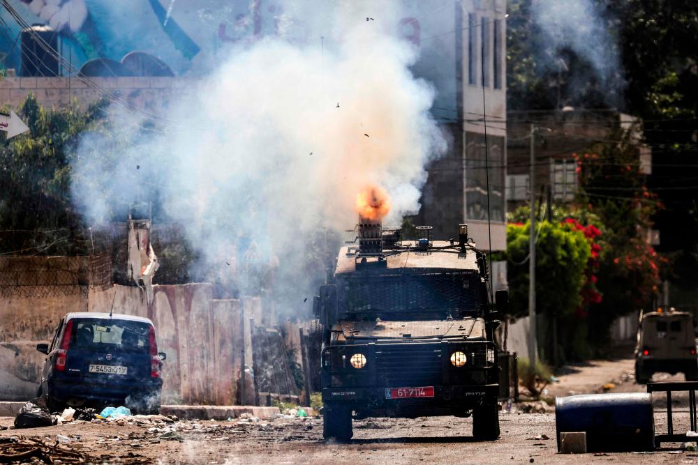 An Israeli armoured vehicle fires tear gas during an ongoing military operation in Jenin city in the occupied West Bank on July 4, 2023. AFPPIX