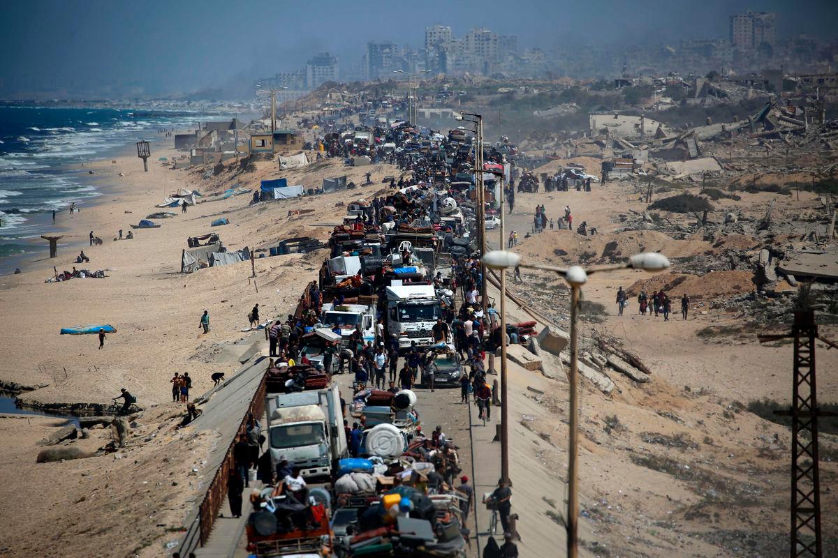 Palestinians from Gaza City move southwards with their belongings, on the coastal road near the Nuseirat refugee camp in the central Gaza Strip, on September 19, 2025. (Photo by Eyad BABA / AFP)
