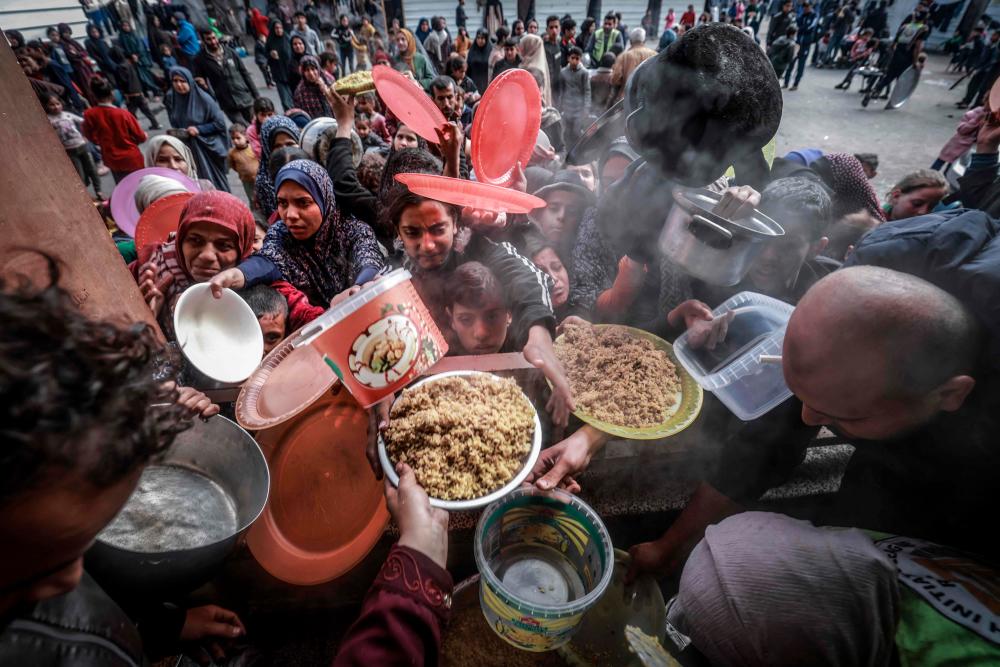 Filepix: Displaced Palestinians gather to receive food at a government school in Rafah in the southern Gaza Strip on February 19, 2024, amid the ongoing battles between Israel and the militant group Hamas/AFPPix