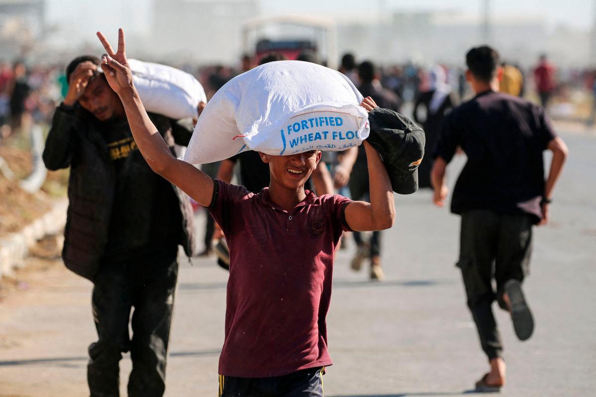 Displaced Palestinians ferry bags of food aid after storming a World Food Programme warehouse in Deir el-Balah in the central Gaza Strip on May 28, 2025 AFPpix