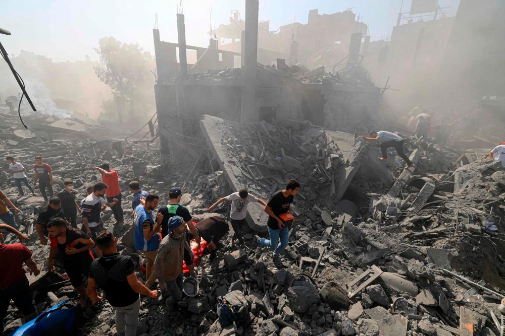 People search for survivors and the bodies of victims through the rubble of buildings destroyed during Israeli bombardment, in Khan Yunis in the southern Gaza Strip on October 26, 2023, amid the ongoing battles between Israel and the Palestinian group Hamas/AFPPix