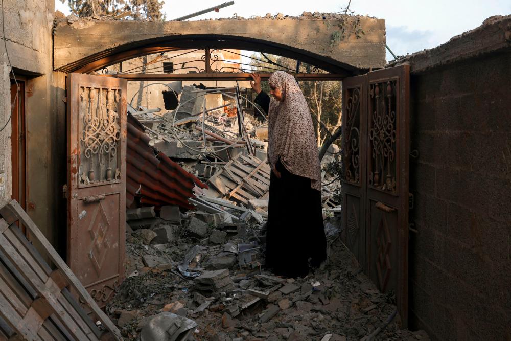 A woman inspects the damage to her home after Israeli strikes on the Rafah camp in the southern Gaza Strip on October 14, 2023. AFPPIX