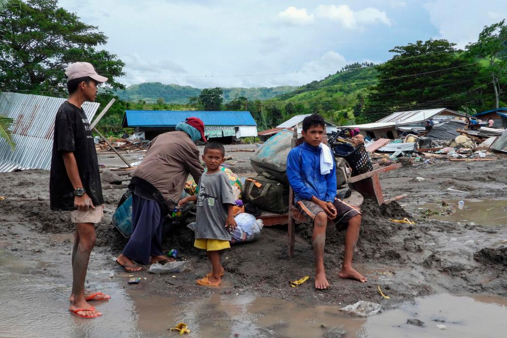 Residents gather next to their belongings by destroyed homes in the landslide-hit village of Kusiong in Datu Odin Sinsuat in the southern Philippines’ Maguindanao province/AFPPix