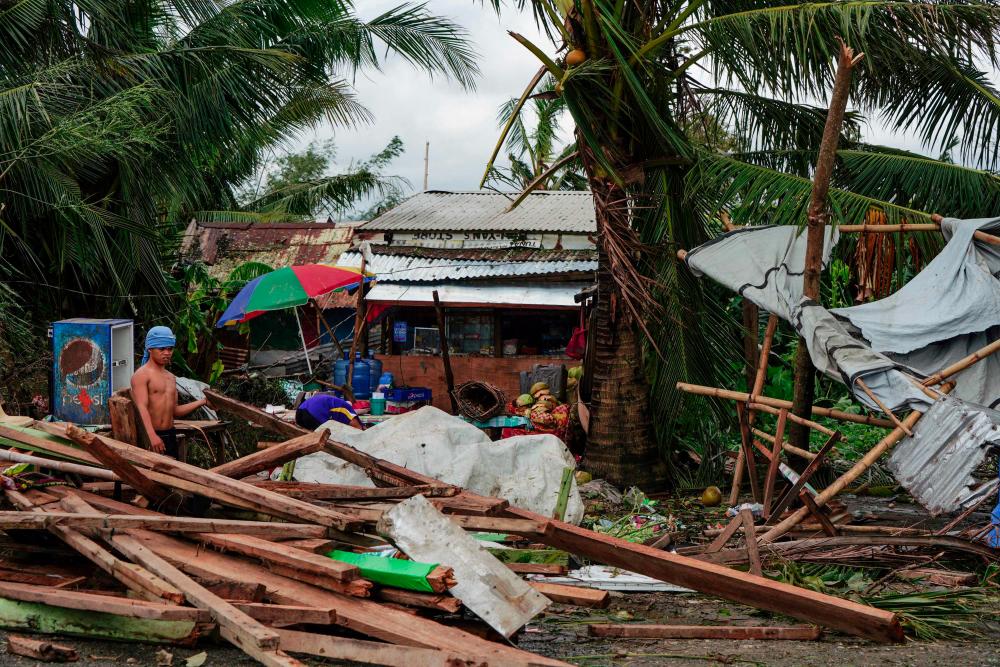 A resident looks at a house damaged at the height of Typhoon Phanfone in Tacloban, Leyte province in the central Philippines on Dec 25. — AFP