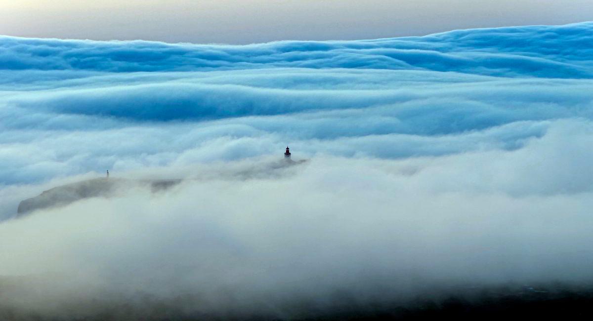 Picture taken On June 29, 2025 with a drone, shows a rare roll cloud, a huge horizontal cloud advancing from the horizon towards the beaches of the Atlantic Ocean during the heatwave near Cabo da Roca, southwestern Portugal. - AFPPIX