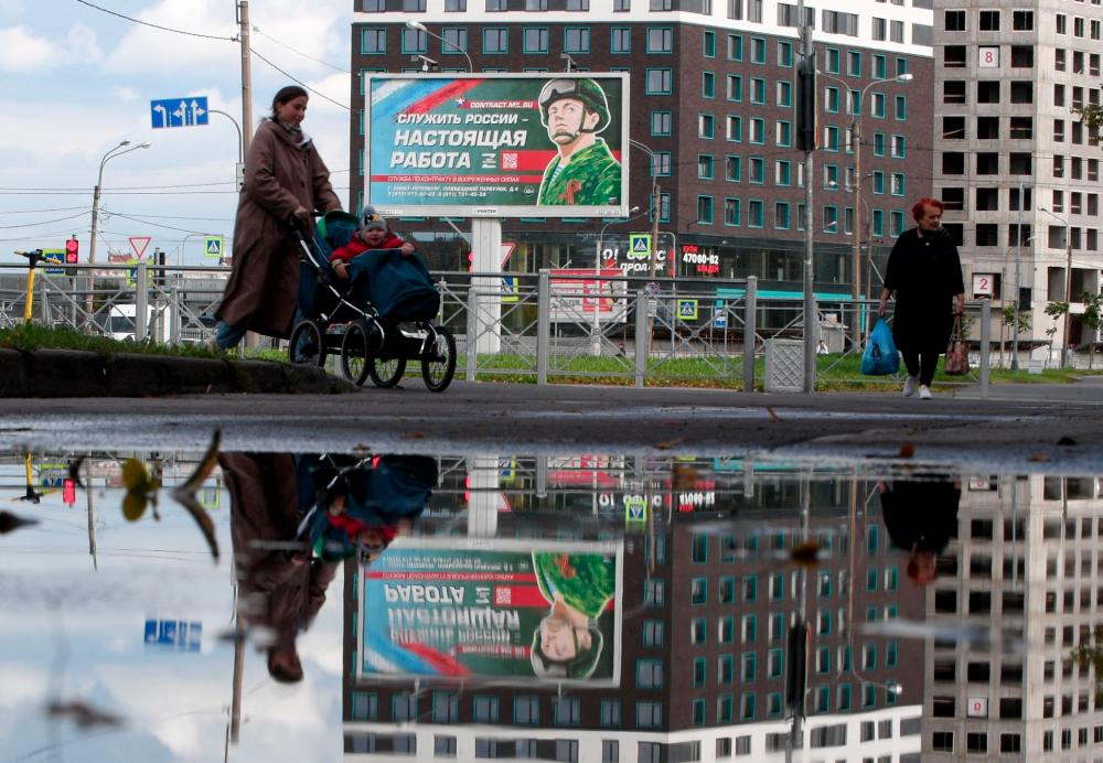 TOPSHOT - A billboard promoting contract army service with an image of a serviceman and the slogan reading Serving Russia is a real job sits in Saint Petersburg on September 20, 2022. - AFPPIX