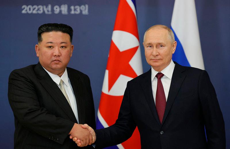 This pool image distributed by Sputnik agency shows Russian President Vladimir Putin (R) and North Korea's leader Kim Jong Un (L) shaking hands during their meeting at the Vostochny Cosmodrome in Amur region on September 13, 2023, ahead of planned talks that could lead to a weapons deal with Russian President. - Vladimir SMIRNOV / POOL / AFP