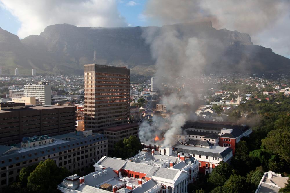 TOPSHOT - A general view of a building on fire at the South African Parliament precinct in Cape Town on January 2, 2022. A major fire broke out in the South African parliament building in Cape Town on January 2, 2022.Firefighters were present at the building as large flames and a huge column of smoke were seen at around 0530 GMT. AFPPIX