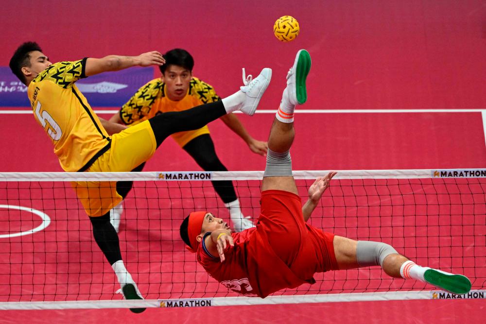 Thailand's Varayut Jantarasena (R) kicks the ball as Malaysia's Mohamad Azlan Bin Alias (L) defends in the men's team final of the sepak takraw event during the Hangzhou 2022 Asian Games in Jinhua in China's eastern Zhejiang province on September 29, 2023. AFPPIX