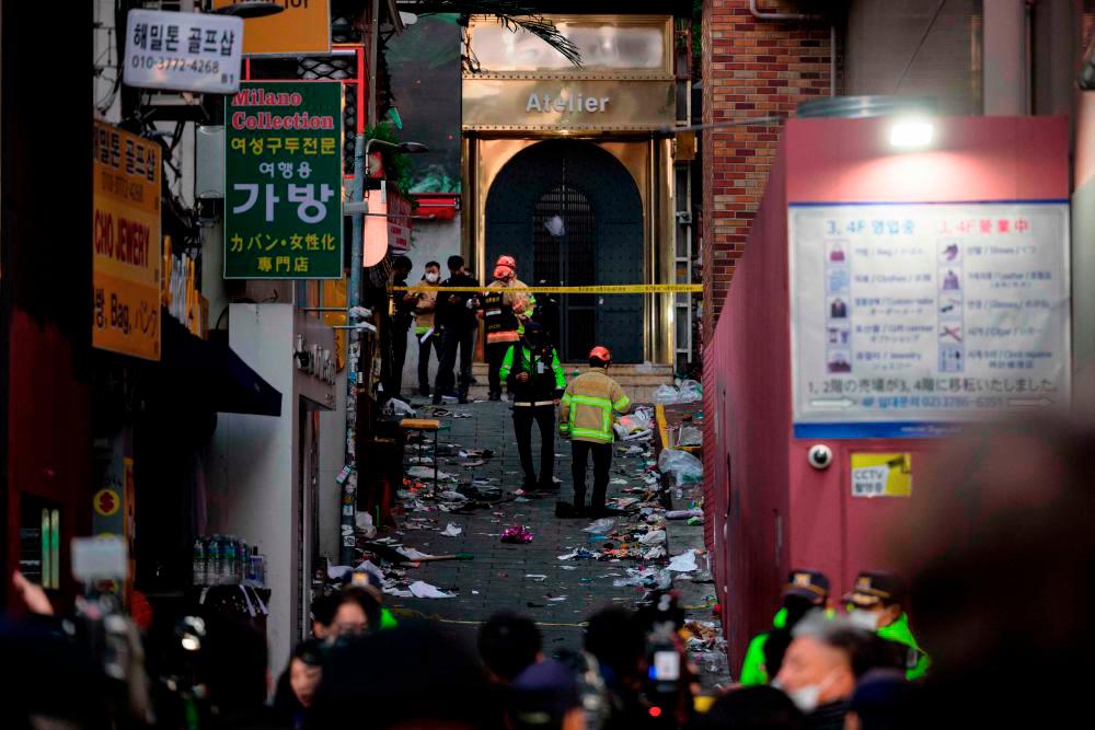 Emergency service personnel are seen in the alley where a Halloween stampede took place late October 29, in the neighbourhood of Itaewon in Seoul on October 30, 2022. AFPPIX
