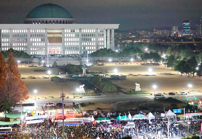 People gather outside the National Assembly in Seoul on December 4, 2024, after South Korea President Yoon Suk Yeol declared martial law. South Korea’s President Yoon Suk Yeol on December 3, declared martial law, accusing the opposition of being “anti-state forces” and saying he was acting to protect the country from “threats” posed by the North. - YONHAP / AFP