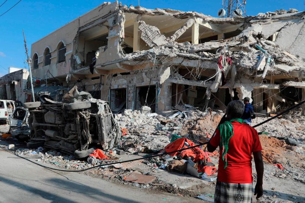 A local residents looks at debris from a destroyed buildings in Mogadishu. – AFPPIX