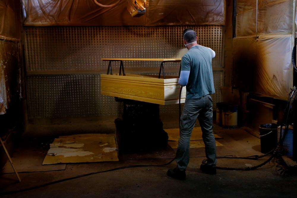 An employee makes a coffin at the Eurocoffin coffins factory in Barcelona on April 3, 2020. — AFP