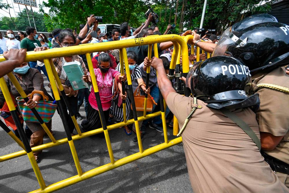 Activists from Samagi Vanitha Balawegaya, a part of the main opposition party Samagi Jana Balawegaya try to overturn a police barricade during a protest outside Sri Lanka’s Prime Minister Ranil Wickremesinghe’s private residence, amid the country’s economic crisis, in Colombo on June 22, 2022. AFPPIX