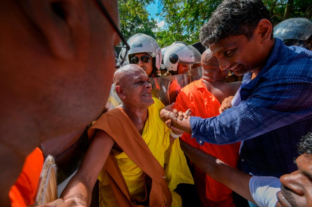A group of hardline Buddhist monks and anti-government demonstrators scuffle with police near the parliament during a protest against the President Ranil Wickremesinghe’s plan to devolve powers to minority Tamils under the country’s 13th amendment in Colombo on February 8, 2023. AFPPIX