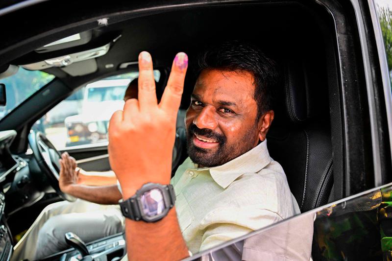 Sri Lankan President Anura Kumara Dissanayake shows his inked finger as he leaves a polling station after casting his ballot to vote in Sri Lanka's parliamentary election in Colombo on November 14, 2024. Sri Lankans were voting in snap parliamentary elections on November 14, with new leftist President Anura Kumara Dissanayake's party expected to secure a mandate to drive through economic reforms. - Ishara S. KODIKARA / AFP