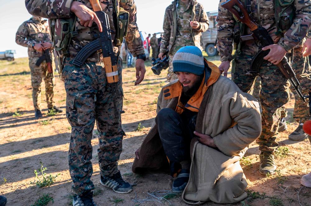 A man from Bosnia suspected of being an Islamic State (IS) group fighter is searched by members of the Kurdish-led Syrian Democratic Forces (SDF) after leaving the IS group's last holdout of Baghouz, in Syria's northern Deir Ezzor province on March 1, 2019. — AFP