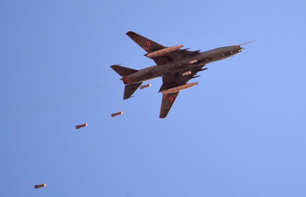 A Sukhoi Su-22 Syrian army plane releases bombs over southern Damascus in the area of Yarmuk Palestinian refugee camp on April 24, 2018. — AFP