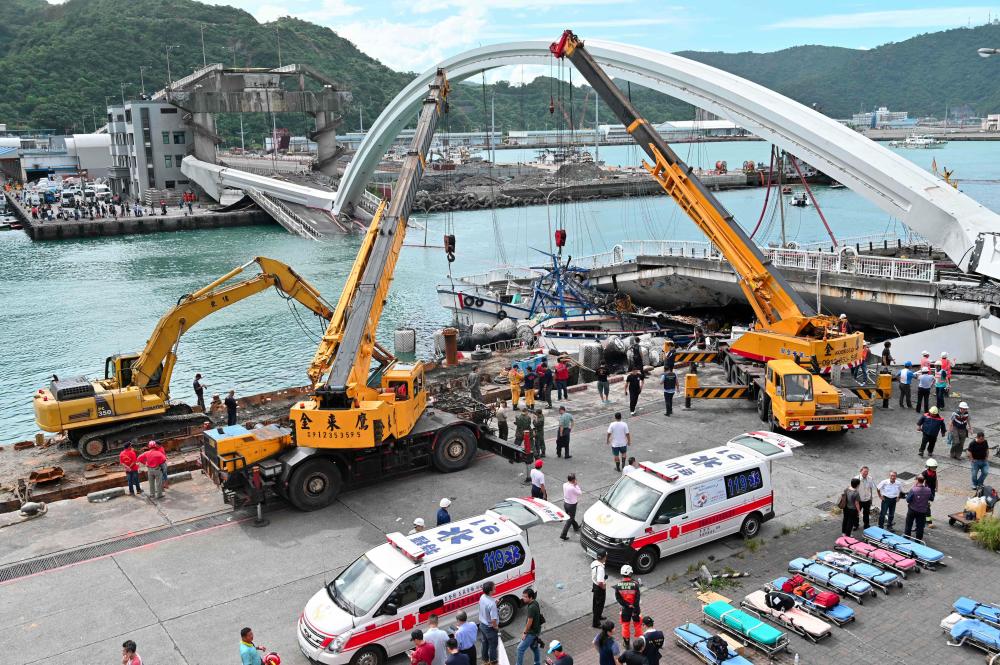 Rescue teams work at the site of a collapsed bridge in Nanfangao harbour in Suao township on Oct 1, 2019. — AFP
