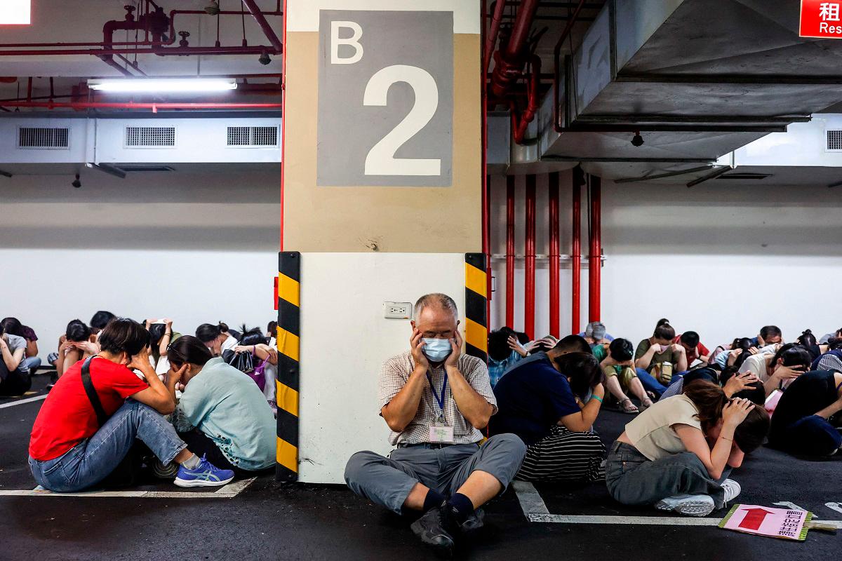 People take shelter during an air raid drill coinciding with the Kan Huang military exercises in Taipei on July 17, 2025. The annual civilian drill is being held in cities across Taiwan this week, alongside military training, to prepare the self-governed island for a potential Chinese invasion. - I-Hwa Cheng / AFP