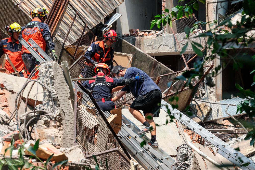 This photo taken by Taiwan’s Central News Agency (CNA) on April 3, 2024 shows emergency workers assisting a survivor after he was rescued from a damaged building in New Taipei City, after a major earthquake hit Taiwan’s east/AFPPix