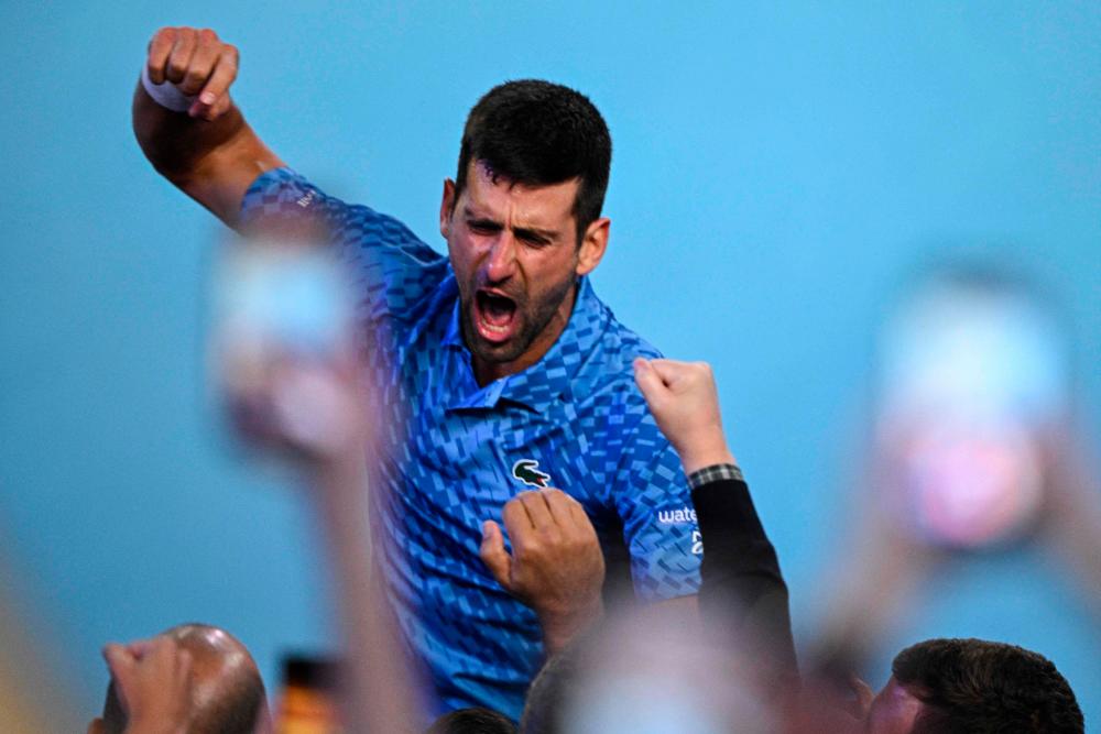 Novak Djokovic dari Serbia meraikan kemenangannya menentang pemain Greece Stefanos Tsitsipas semasa perlawanan akhir perseorangan lelaki pada hari keempat belas kejohanan tenis Terbuka Australia di Melbourne pada 29 Januari 2023. fotoAFP