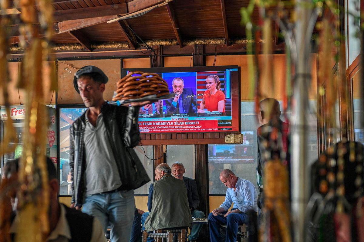 This photograph shows a screen announcing of PKK's (Kurdish Workers Party) dissolution on the News on a television screen inside a traditional Turkish tea house, in Diyarbakir, on May 12, 2025. - AFPPIX