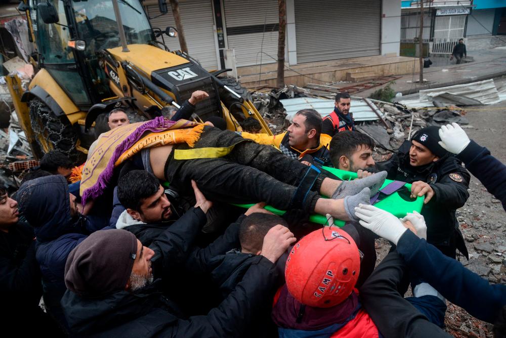 Rescue workers and volunteers pull out a person from the rubble in Diyarbakir on February 6, 2023, after a 7.8-magnitude earthquake struck the country’s south-east. AFPPIX