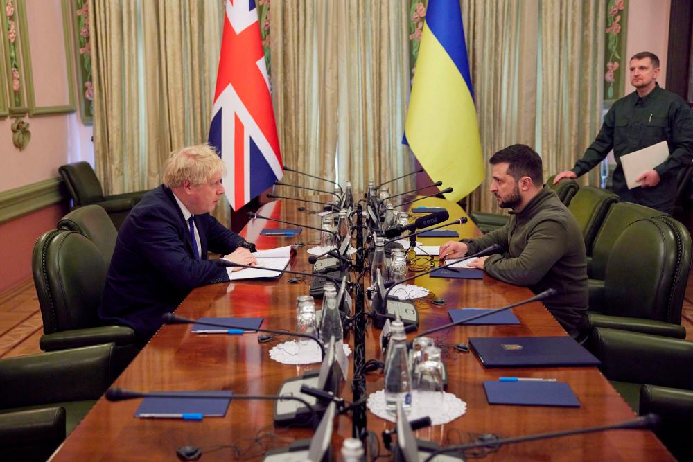 This handout picture taken and released on April 9, 2022 by Ukrainian Presidential Press Service shows Ukrainian President Volodymyr Zelensky (2R) speaking with British Prime Minister Boris Johnson (L) during their meeting in Kyiv. AFPPIX