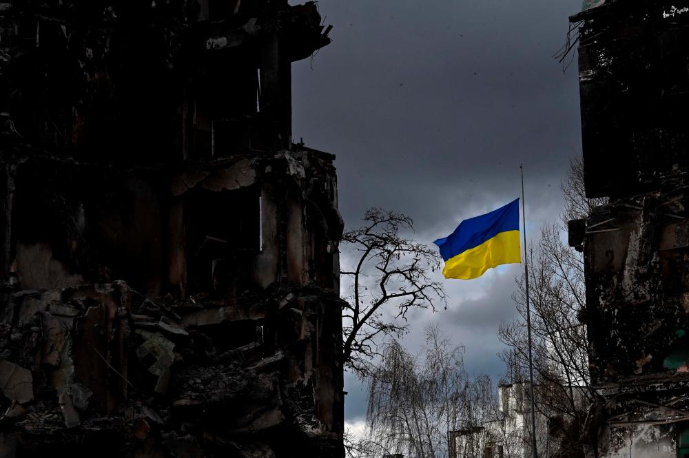 The Ukrainian flag flutters between buildings destroyed in bombardment, in the Ukrainian town of Borodianka, in the Kyiv region on April 17, 2022. AFPPIX