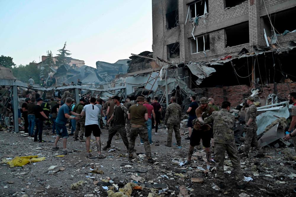 Rescuers and volunteers work to rescue people from under the rubble after a Russian missile strike hit a restaurant and several houses in Kramatorsk, eastern Ukraine, on June 27, 2023/AFPPix