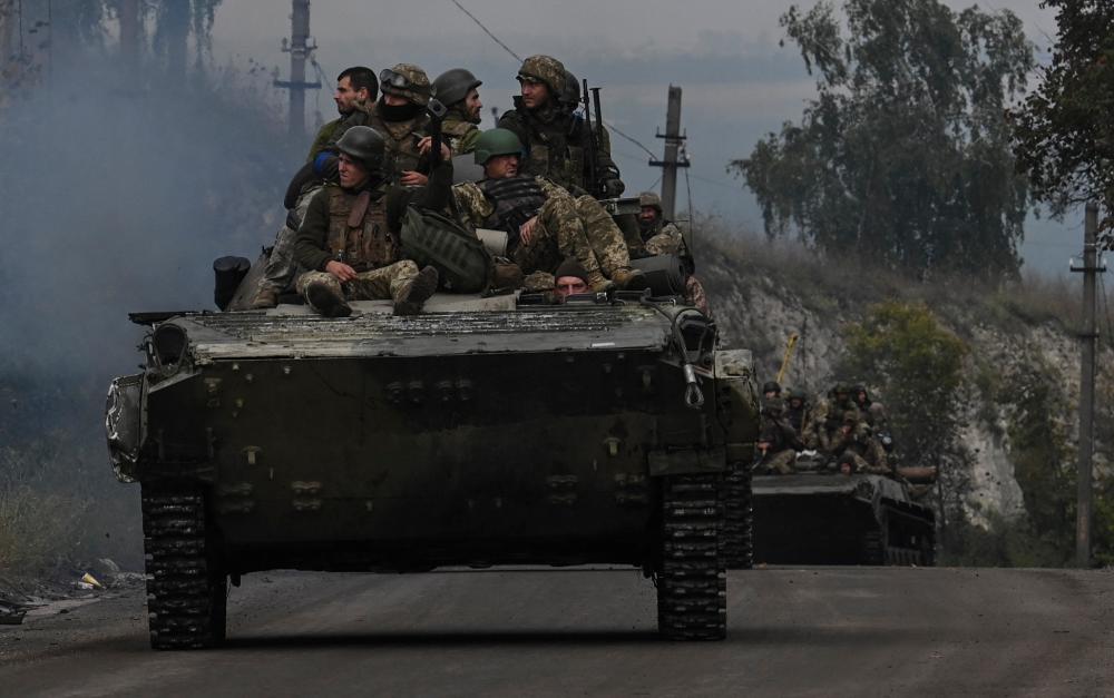 Ukrainian soldiers sit on infantry fighting vehicles as they drive near Izyum, eastern Ukraine on September 16, 2022, amid the Russian invasion of Ukraine. AFPPIX