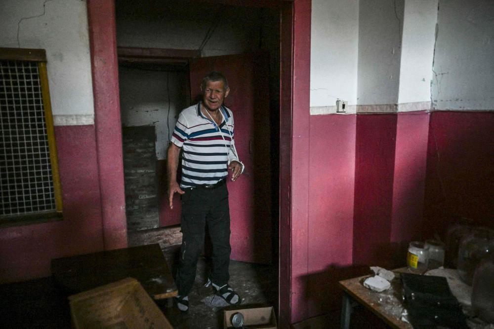 TOPSHOT - Mykhailo Tchindey walk into a prison cell in a destroyed police station of in Izyum, eastern Ukraine on September 18, 2022. - AFPPIX