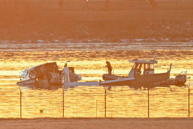 Part of the wreckage is seen as rescue boats search the waters of the Potomac River after a plane on approach to Reagan National Airport crashed into the river near Washington - AFPpix