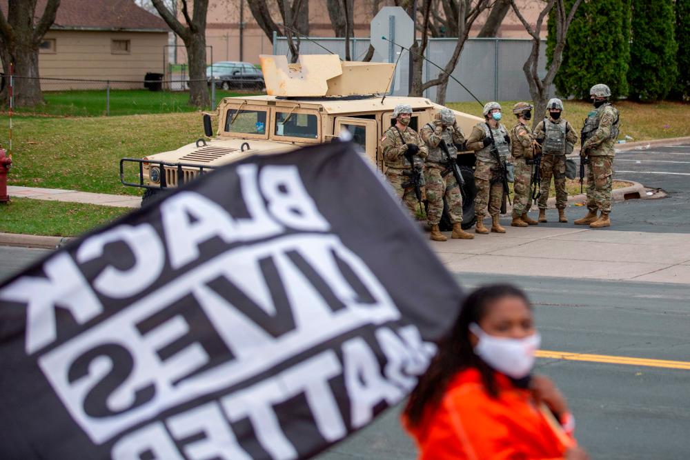 Minnesota National Guard and law enforcement members stand guard outside the Brooklyn Center Police Station after a police officer shot and killed a Black man in Brooklyn Center, Minneapolis, Minnesota on April 12, 2021. –AFP