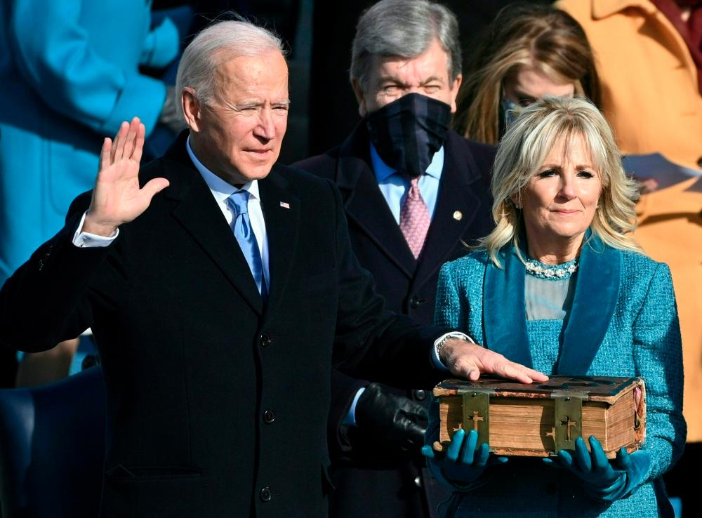 TOPSHOT - Joe Biden, flanked by incoming US First Lady Jill Biden takes the oath of office as the 46th US President by Supreme Court Chief Justice John Roberts during the swearing-in ceremony of the 46th US President on January 20, 2021, at the US Capitol in Washington, DC. AFP / Brendan SMIALOWSKI
